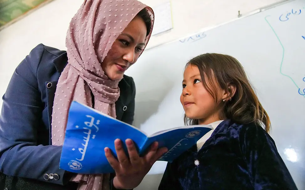 Eine Lehrerin in Afghanistan prüft mit einer Schülerin die Hausaufgaben | © UNICEF/Fazel Lieblingsfoto 2023: Eine Lehrerin in Afghanistan im Gespräch mit einer Schülerin
